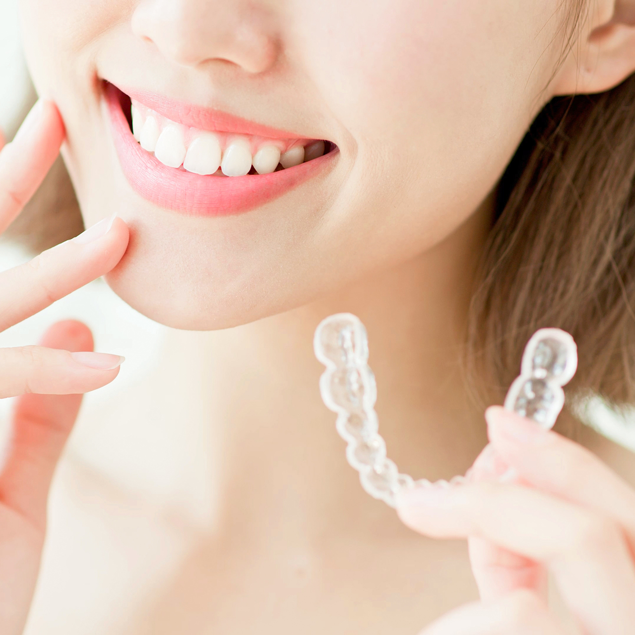 マウスピースを持つ女性 - 芦別矯正歯科相談室